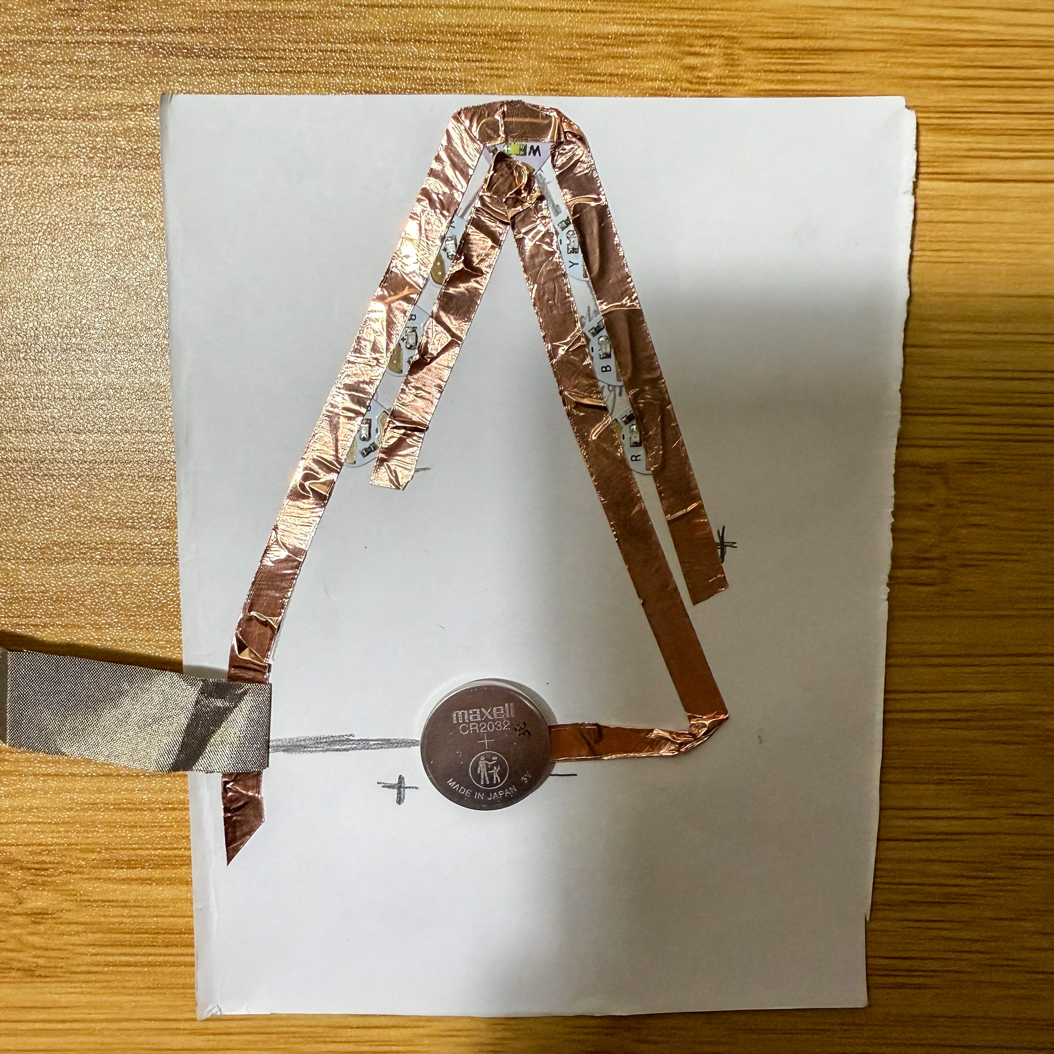 Using the conductive fabric as a button which connects the battery to the circuit. Placing the battery in the correct positive and negative position and ready to test.