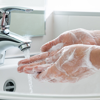 The continuous sound of water flowing from a faucet, accompanied by the subtle scrubbing of hands.